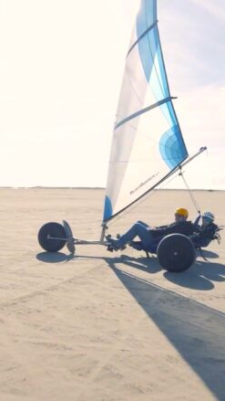 En dobbelt strandsurfer på en flad bred strand.