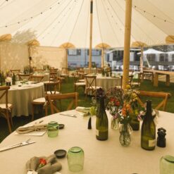 Smukt opdækket bord i en kanvastelt - venter på gæster til sommerfest.