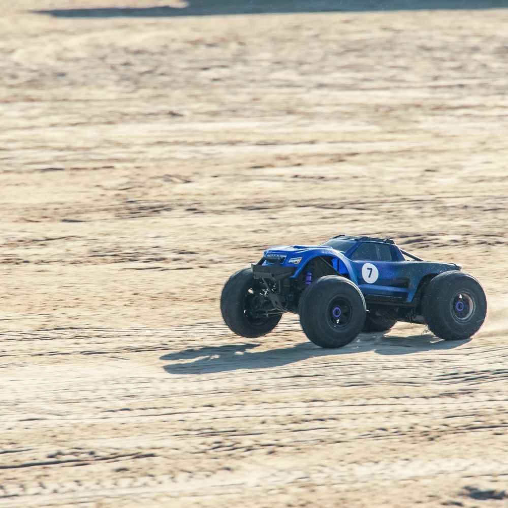 En enkelt fjernstyret bil ræser afsted på en strand. At køre med Radio Control Cars er en sjov oplevelse for alle. I inddeles på hold, så I kan få en fornemmelse af konkurrence, samarbejde og har det sjovt sammen.