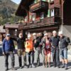 En gruppe mennesker står i en Schweizisk landsby iført hjelme og klatreseler. På firmarejse til Interlaken, Schweitz.
