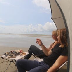 2 piger nyder roen og udsigten på en af Danmarks smukke strande med en Glamnic oplevelse - et nyt picnic koncept, der kombinerer det bedste fra en picnic i naturen med komfort og luksus.