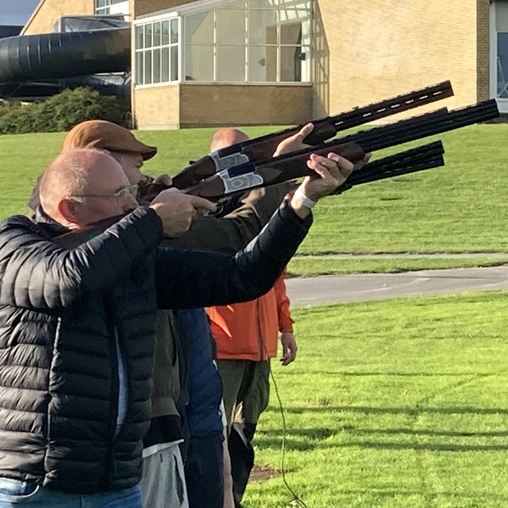 En gruppe mænd lægger an til skydning mod lerduer. Få en sikker og sjov skydeoplevelse: ren action og sjov! Perfekt til events. Laser lerdueskydning er ideelt til teambuilding, hvor alle kan være med og bidrage til holdets succes.