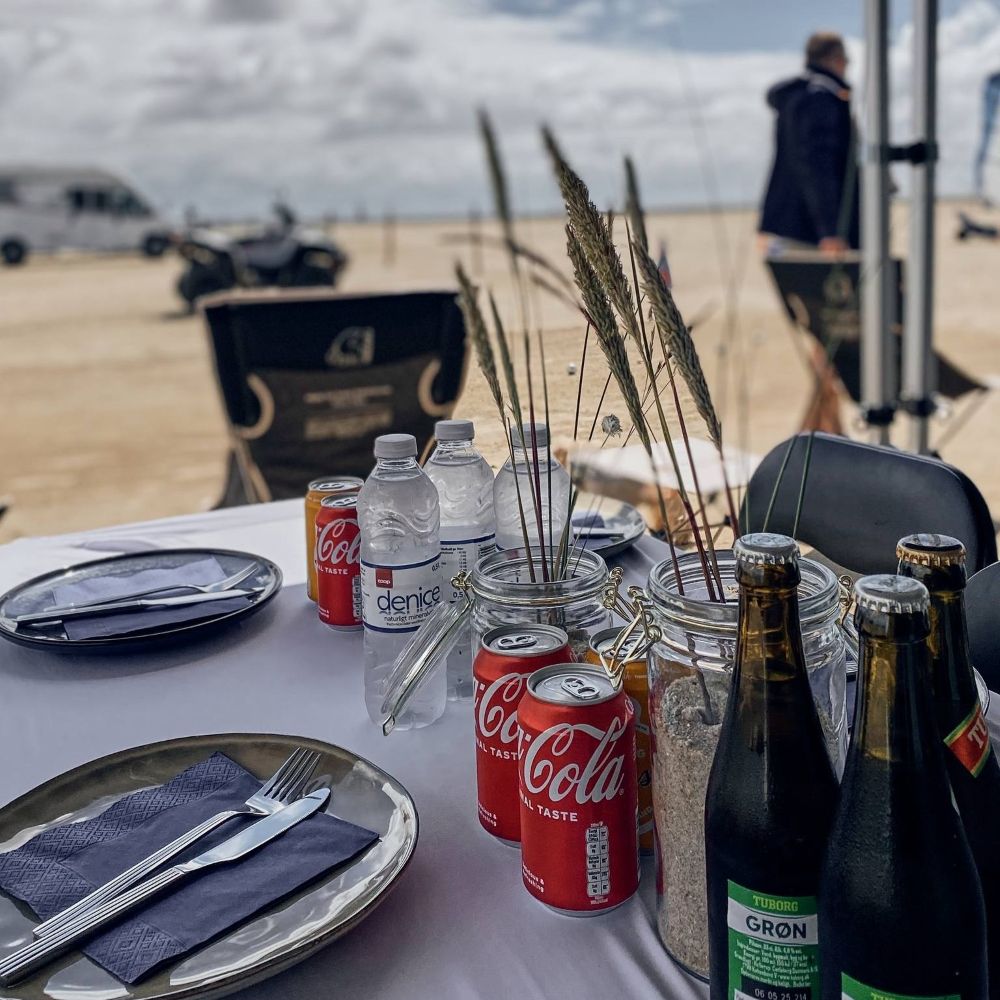 Kolde drikkevarer står klar efter en aktivitet på stranden i forbindelse med et Outdoor Meeting/konference: vi sætter telt og stole op for jer i forbindelse med afvikling af jeres event, hvor I så kan afholde et møde samtidigt.