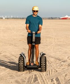 En ung mand kører på Segway på en strand, hvor solen skinner. Book jeres næste event med os og oplev, hvordan et Segway Event kan løfte teamets samarbejde til nye højder!
