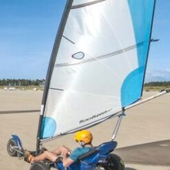 To strandsurfere kører på en flad, bred strand på Rømø på en dag med blå himmel.